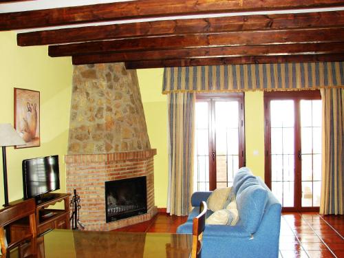 Una sala de estar con un sofá azul y una chimenea. en Apartamentos Sierra de Segura, en Segura de la Sierra