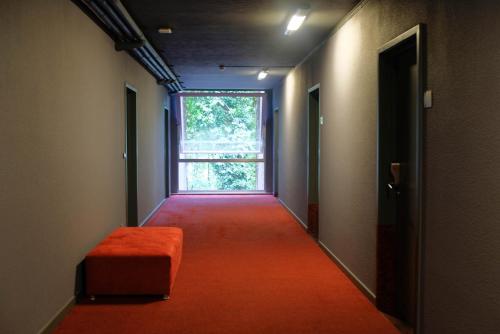 an empty hallway with an orange bench and a window at Corbie Mol in Mol