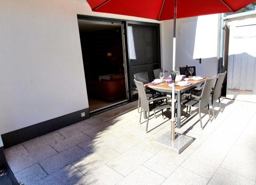 - une table et des chaises avec un parasol dans la chambre dans l'établissement Ferienhaus GOLFER_S HOUSE, à Göhren-Lebbin