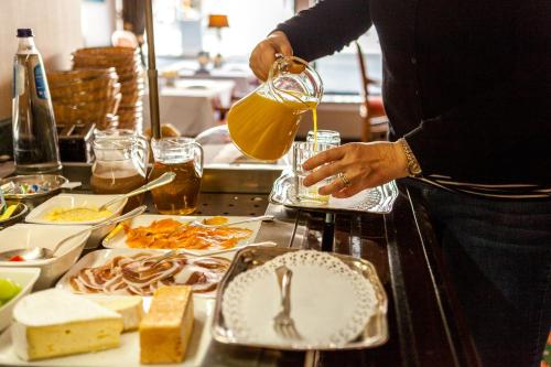 a person standing in a kitchen preparing food at Malecot Hotel by F-Hotels in Blankenberge