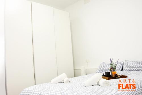 a white bedroom with a bed with arts flags on it at Calle Cuenca in Valencia