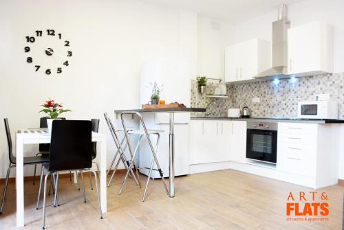a kitchen with a table and a clock on the wall at Calle Cuenca in Valencia