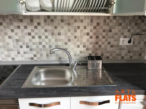 ein Edelstahlspülbecken in einer gefliesten Küche in der Unterkunft CALLE CUENCA 2 in Valencia