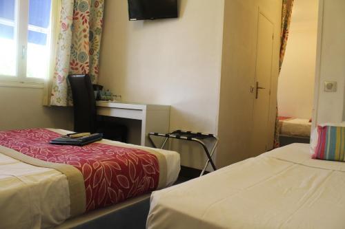 a hotel room with two beds and a television at Hotel Cayrons Vence & St Paul de Vence in Vence