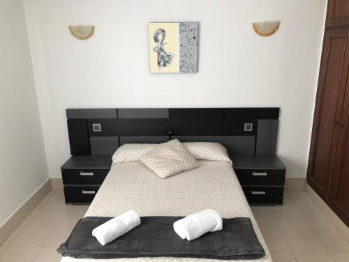 a bedroom with a large black bed with two pillows at Hotel Costa Mar in Loredo