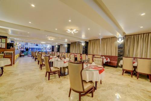 a dining room filled with tables and chairs at FabHotel Prime Sarala Crown Calangute Beach - Fully Vaccinated Staff in Calangute