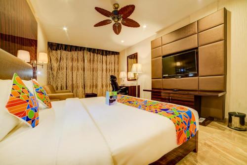 a hotel room with a large bed and a television at FabHotel Prime Sarala Crown With Pool, Calangute Beach in Calangute