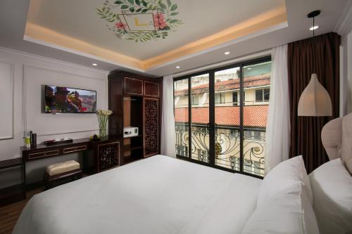 a bedroom with a bed and a large window at Golden Legend Palace Hotel & Travel in Hanoi