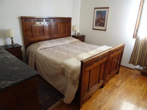 een slaapkamer met een groot houten bed en houten vloeren bij I Faggi Rossi in Fanano