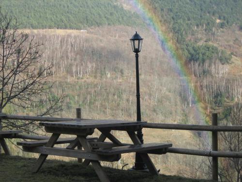 a picnic table with a street light and a rainbow at Apartaments Fontalba in Queralbs