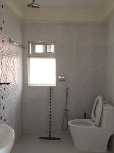 a bathroom with a toilet and a sink and a window at Green Mandala Inn in Kathmandu