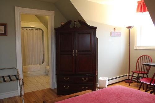 a bedroom with a dark wooden cabinet in a room at Ye Olde Argyler Lodge in Pubnico