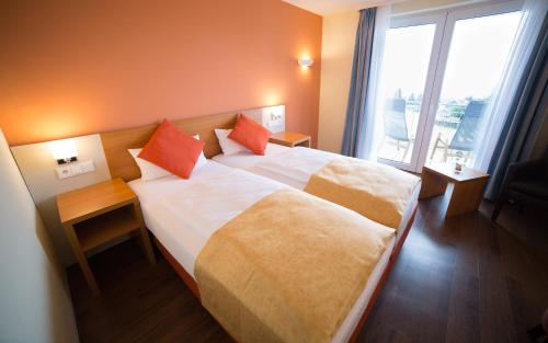 a hotel room with a bed and a large window at Berghotel Tambach in Tambach-Dietharz