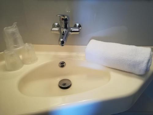 a white bathroom sink with a towel on it at Premiere Classe Vichy - Bellerive Sur Allier in Bellerive-sur-Allier