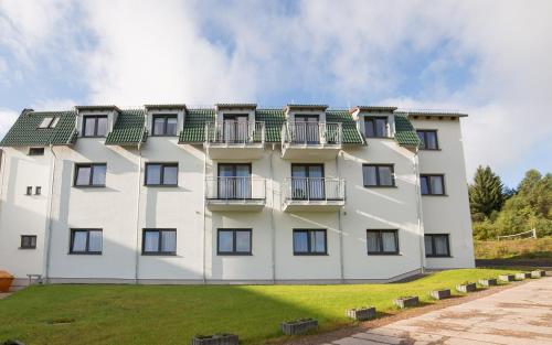 a large white building with a green roof at Berghotel Tambach in Tambach-Dietharz