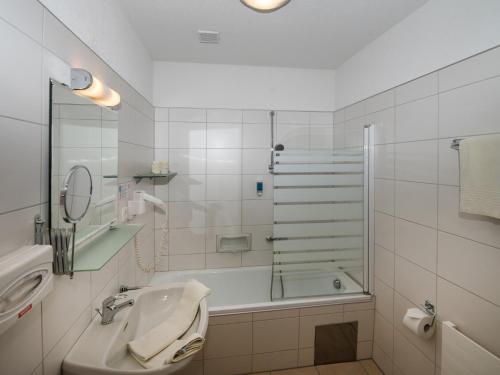 W łazience znajduje się prysznic, umywalka i wanna. w obiekcie Kutscherklause w mieście Eggern