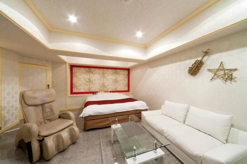 Ciao-LoveHotel في ميازاكي: غرفة معيشة مع أريكة وسرير