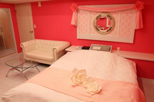 een slaapkamer met een bed, een stoel en een spiegel bij Ciao-LoveHotel in Miyazaki