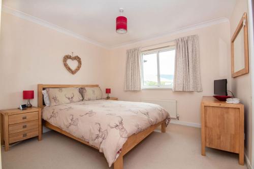 a bedroom with a bed and a window at The View at No10 in Aviemore
