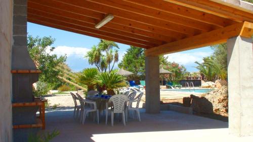 a patio with a table and chairs and a pool at Can Bril in Campos