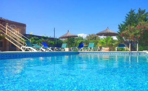 a large swimming pool with chairs and umbrellas at Can Bril in Campos
