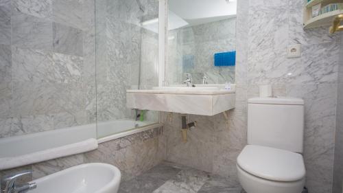 uma casa de banho branca com um WC e um lavatório em Manilva Beach 109 em Manilva