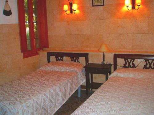 カンポスにあるFinca Sombrillaのベッド2台、テーブル、ランプ2つが備わる客室です。