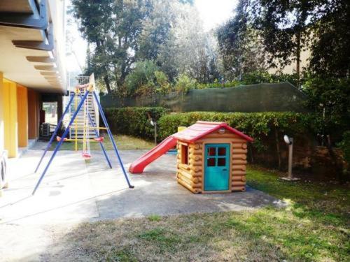 une petite aire de jeux avec un toboggan et une maison de jeux dans l'établissement Hotel Florida Tirrenia, à Tirrenia