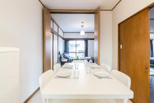 - une salle à manger blanche avec une table et des chaises blanches dans l'établissement Ikebukuro Yamase Building #GR1, à Tokyo