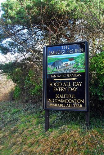 a sign in the grass next to a field at The Smugglers Inn in Weymouth