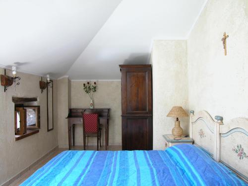 Schlafzimmer mit einem blauen Bett und einem Schreibtisch in der Unterkunft Vigna Della Signora in Morano Calabro