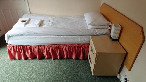 a bed in a room with a box next to it at The Wellington Hotel in Howden
