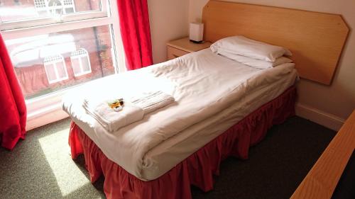 a small bed in a room with a window at The Wellington Hotel in Howden