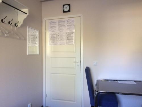 a white door with a clock on a wall at Imatran Portti in Imatra