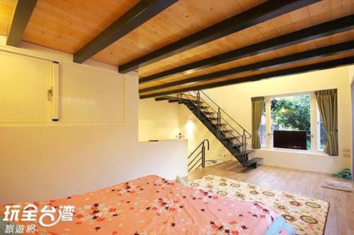 a room with a bed in a room with a staircase at Dongguang Zhixing Homestay in Yuchi