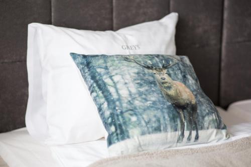 a pillow with a deer on it sitting on a couch at Hotel Greys Polonia in Zasutowo