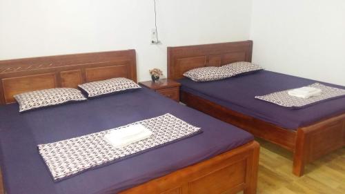 Homestay Lan Rung في Nghĩa Lộ: سريرين في غرفة ذات أغطية أرجوانية
