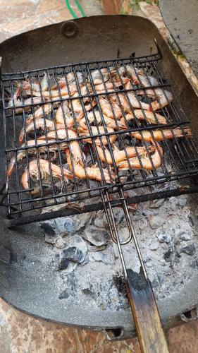 a bunch of food cooking on a grill at Olive Tree Apartment in Sarandë
