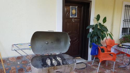 a grill in front of a building with a door at Olive Tree Apartment in Sarandë