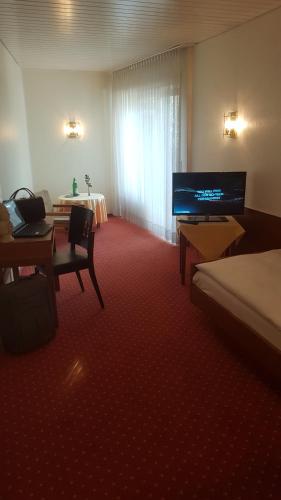 a hotel room with a bed and a table and a television at Hotel Restaurant Rothkopf in Euskirchen