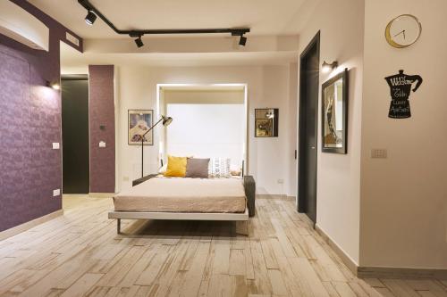 Luxury Experience | WelcHome Napoli في نابولي: غرفة نوم بسرير وساعة على الحائط