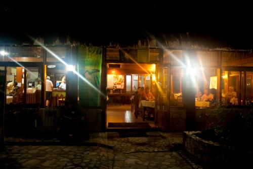 a restaurant at night with people sitting at tables at Hotel Jaguar Inn Tikal in Tikal