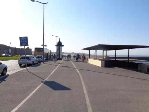 a road next to the beach with people walking and cars at Oporto Foz House close to the beach in Porto