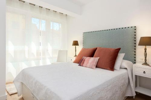グラナダにあるGenteel Home Santo Cristoのベッドルーム(オレンジ色の枕が付いた大きな白いベッド付)