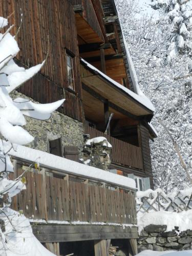 une cabane en rondins sous la neige avec une clôture dans l'établissement L'Epicéa, à Saint-Jean-dʼArves