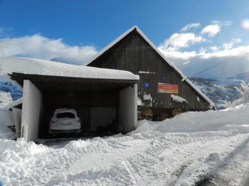 eine schneebedeckte Garage mit einem Auto darin in der Unterkunft L'Epicéa in Saint-Jean-dʼArves