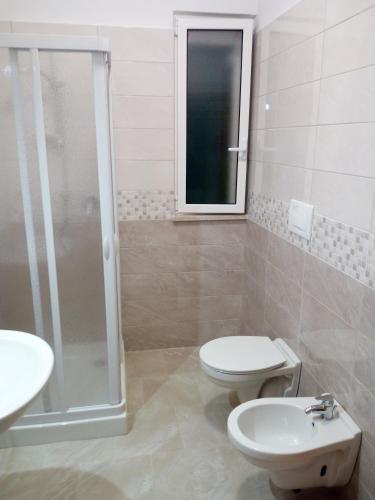 a bathroom with a toilet and a sink and a shower at Villa Anna in Selva di Fasano