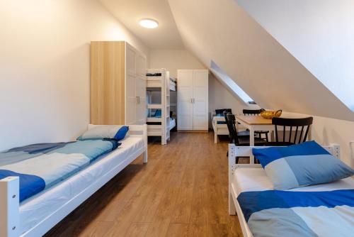 a room with two beds and a dining room with a table at Apart-Hostel ZERO in Bratislava