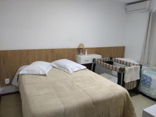 1 dormitorio con cama, mesa y lavamanos en Aluguel Por Temporada Jcl, en Gramado