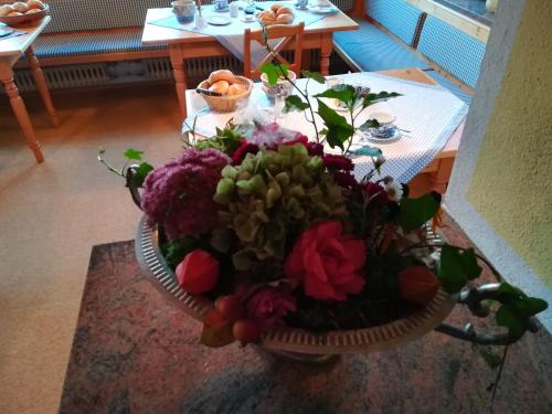 ein Blumenstrauß in einem Korb auf einem Tisch in der Unterkunft Pension Waldklause, Doppelzimmer mit Balkon, Dusche, WC in Königssee